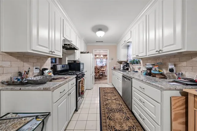 a kitchen with stainless steel appliances granite countertop a sink a stove and cabinets