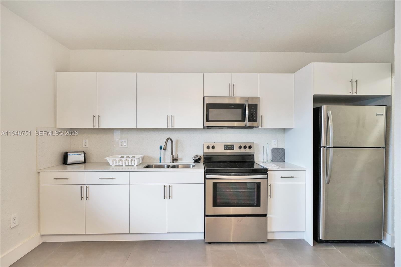 60 Northwest 76th Street, Unit 16 Miami, FL 33150 - Photo 2 of 23 a kitchen with cabinets stainless steel appliances and sink