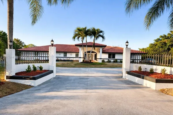 a front view of multi story residential apartment building with swimming pool and wooden fence