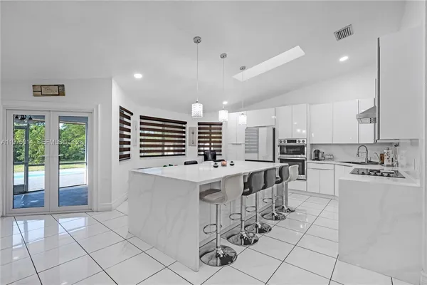a kitchen with a sink a counter top stainless steel appliances and cabinets