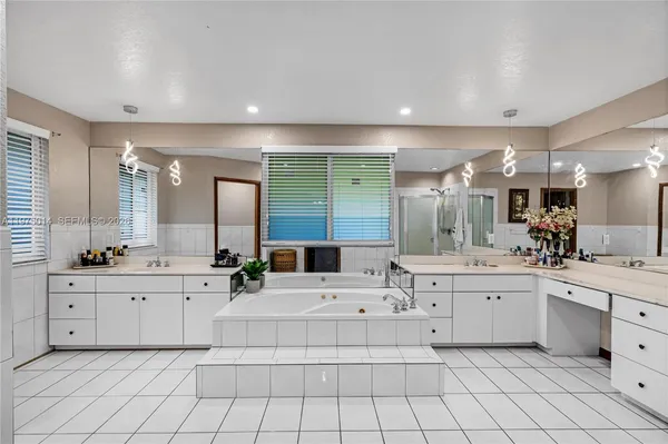 a large white kitchen with a sink and cabinets