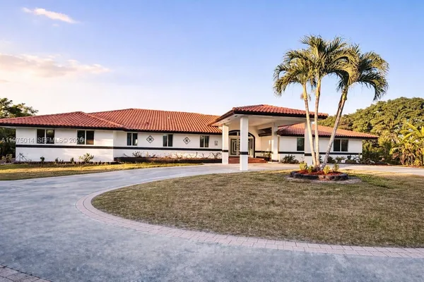 a front view of a house with swimming pool and porch