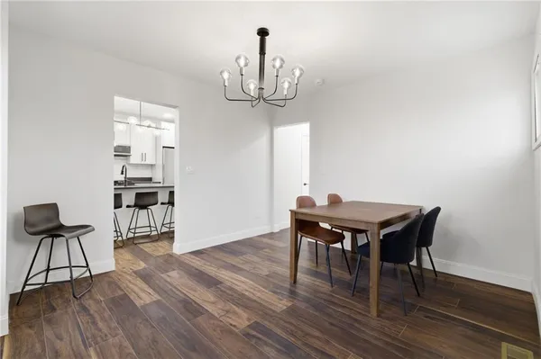 a dining room with furniture a chandelier and wooden floor