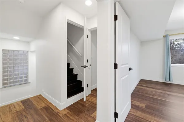 a view of a hallway with wooden floor and staircase