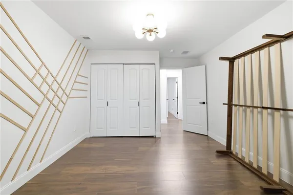a view of a hallway with wooden floor and staircase