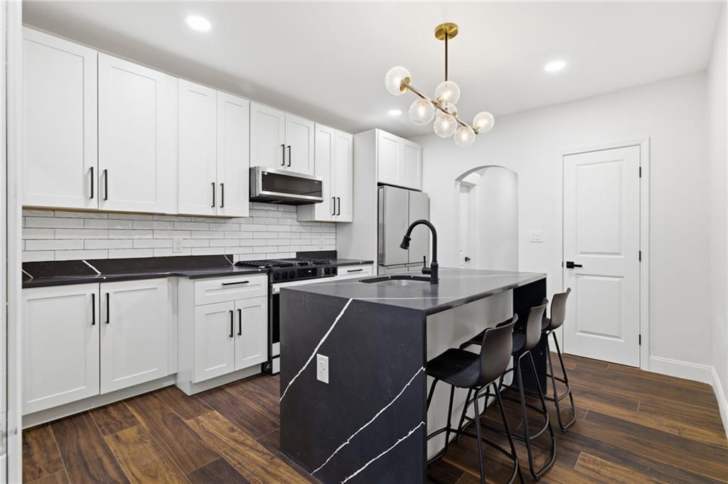 3 3rd Avenue Braddock, PA 15104 - Photo 4 of 46 a kitchen with stainless steel appliances a white table chairs and a refrigerator