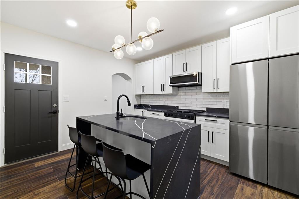 3 3rd Avenue Braddock, PA 15104 - Photo 5 of 46 a kitchen with stainless steel appliances granite countertop a sink a stove a refrigerator and island with wooden floor