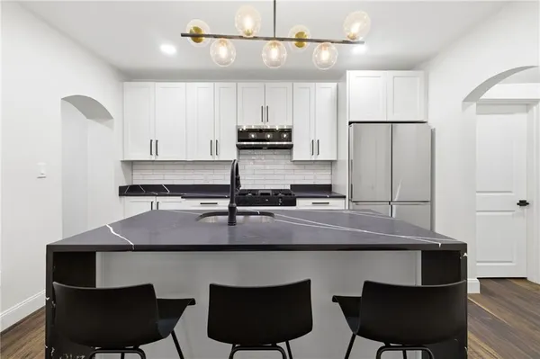 a kitchen with a table chairs stove and cabinets