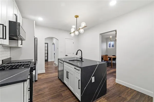 a kitchen with stainless steel appliances granite countertop a stove a sink and a refrigerator