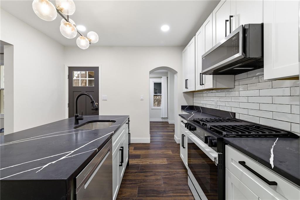 3 3rd Avenue Braddock, PA 15104 - Photo 8 of 46 a kitchen with kitchen island stainless steel appliances a sink cabinets and wooden floor
