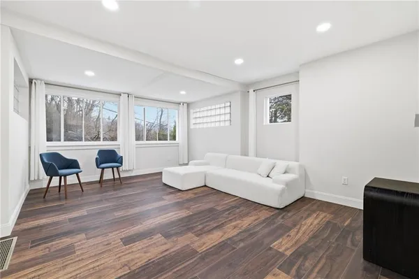 a living room with furniture and a wooden floor