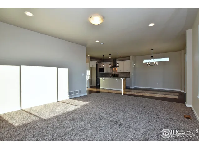 a view of empty room with stairs and wooden floor