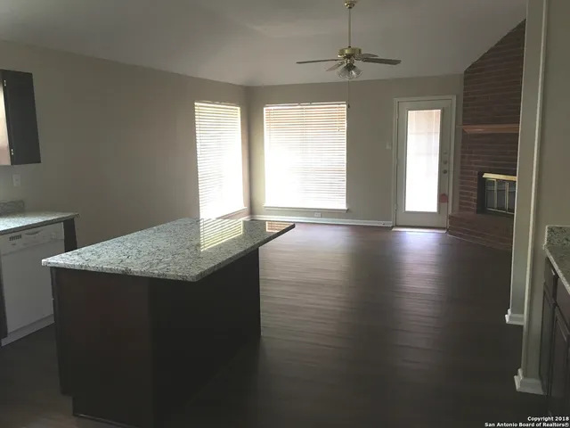 a kitchen with stainless steel appliances granite countertop a sink and a wooden floor