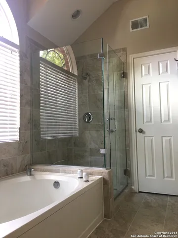 a bathroom with a tub a sink and a shower