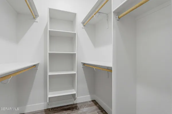 a view of walk in closet with empty racks