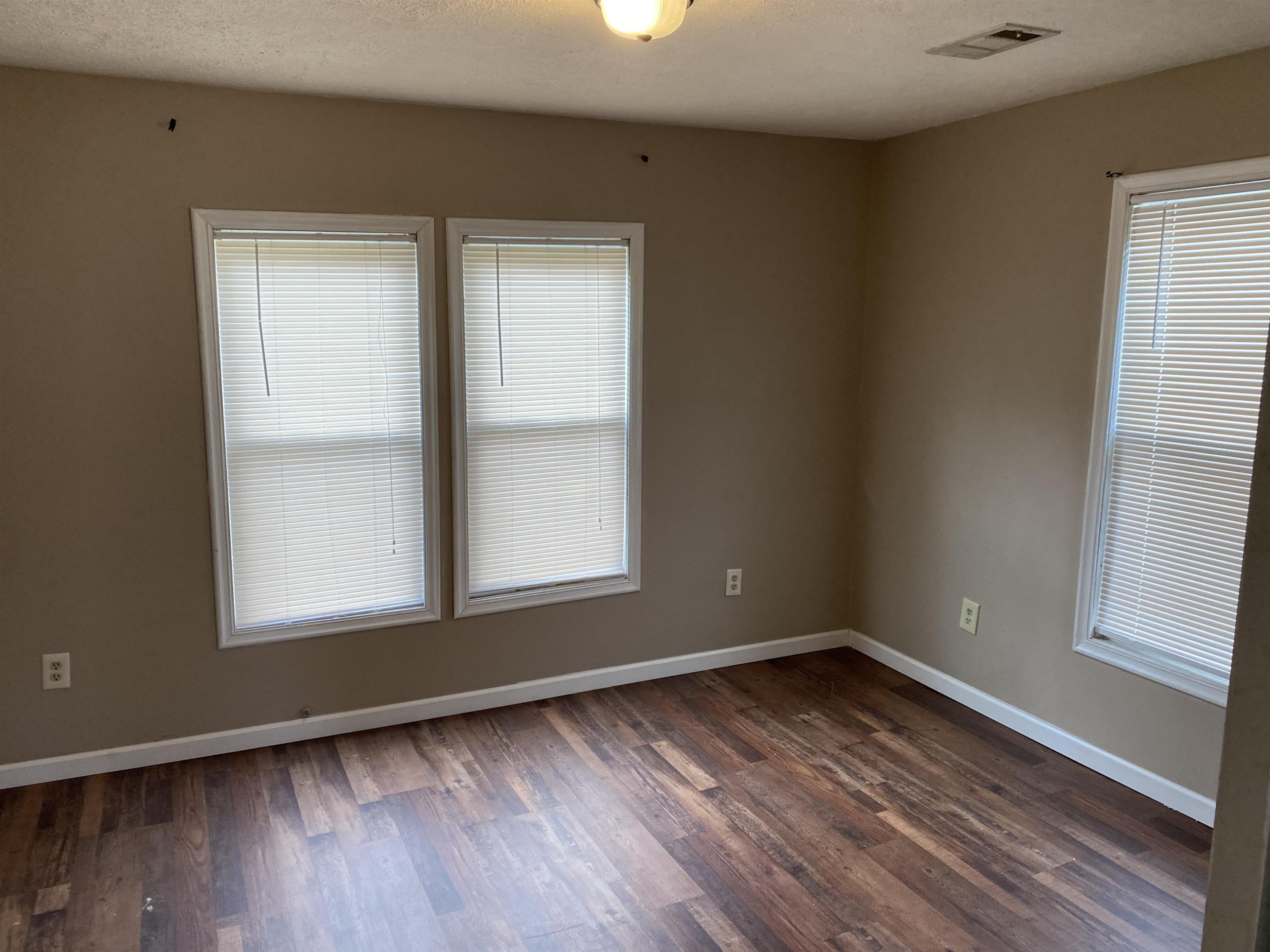 402 West Mill Street Rutherford, TN 38369 - Photo 4 of 5 an empty room with wooden floor and windows