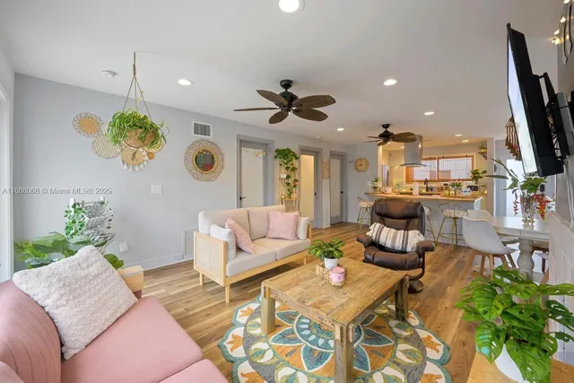 a living room with furniture a dining table and a potted plant
