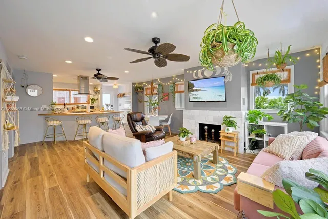 a living room with fireplace kitchen view and a chandelier