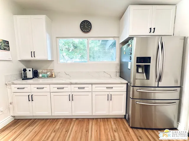 a kitchen with stainless steel appliances a refrigerator sink and cabinets