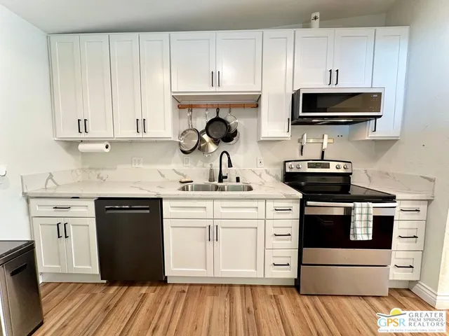 a kitchen with stainless steel appliances granite countertop a stove a sink and a microwave