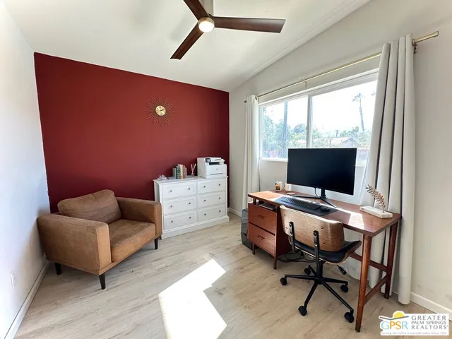 a view of a livingroom with workspace and a window
