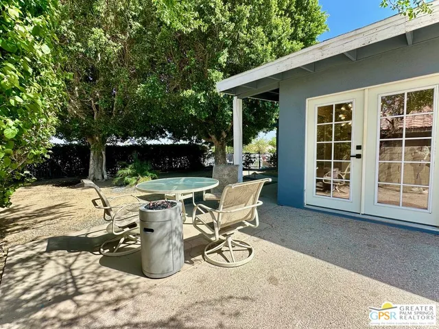 a view of a patio with table and chairs with wooden fence and plants