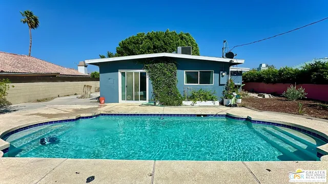 a backyard of a house with table and chairs