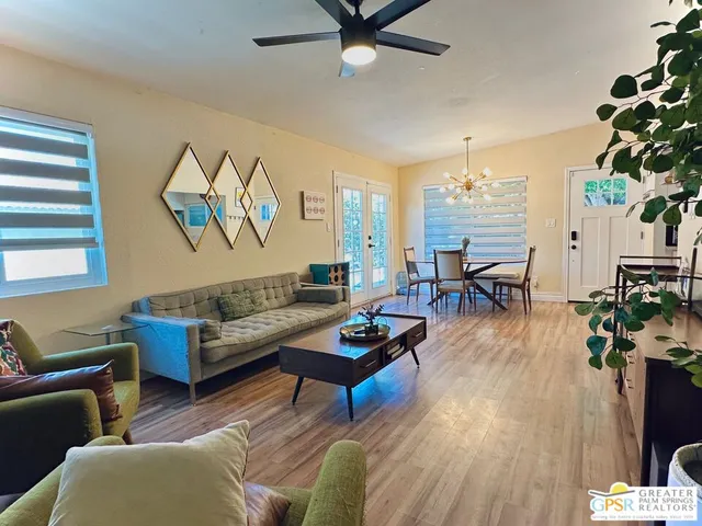a living room with furniture a chandelier and a window