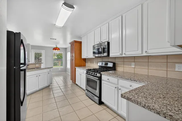 a kitchen with stainless steel appliances granite countertop a refrigerator sink and stove