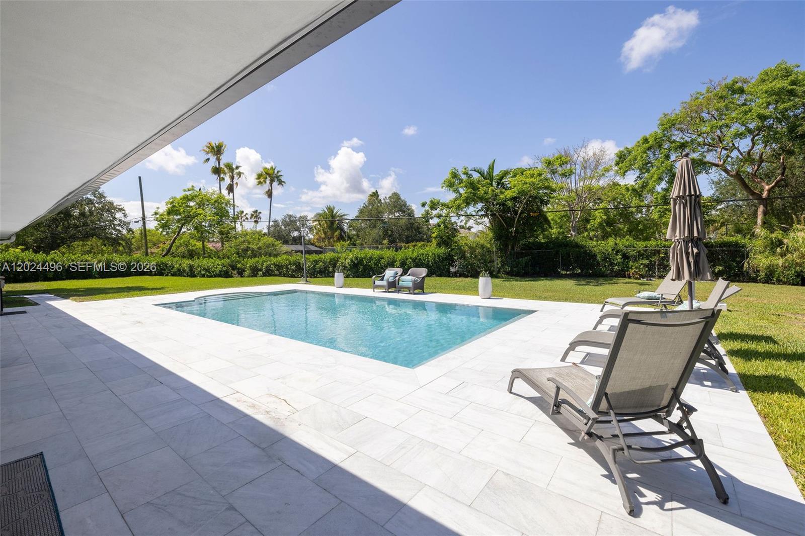 6875 North Cartee Road Palmetto Bay, FL 33158 - Photo 31 of 42 a view of a swimming pool with a lounge chair