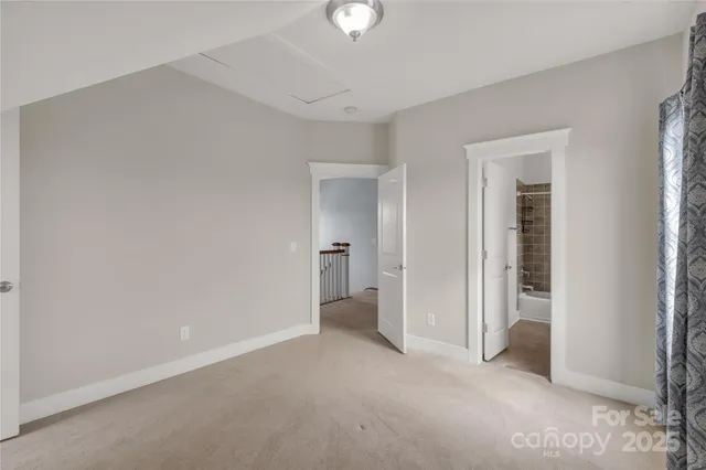 an empty room with closet and a chandelier fan