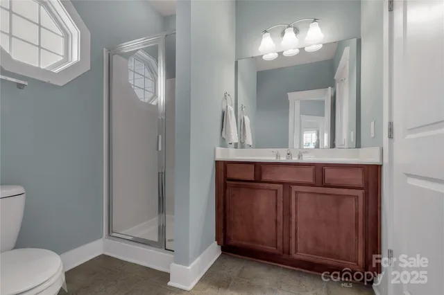 a view of a white house with a yard and table and chairs under an umbrella