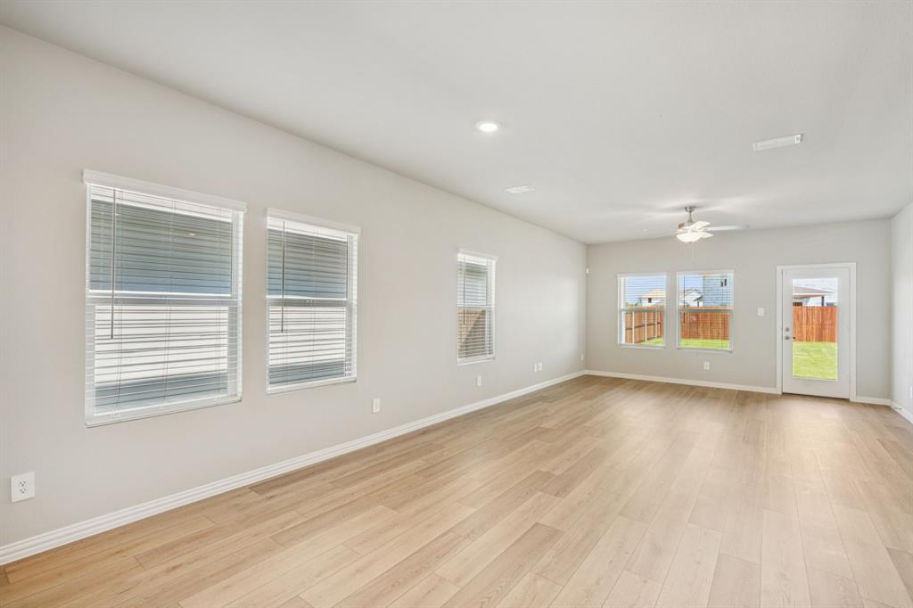 1712 Arches Road Anna, TX 75409 - Photo 12 of 37 a view of an empty room with a window and wooden floor