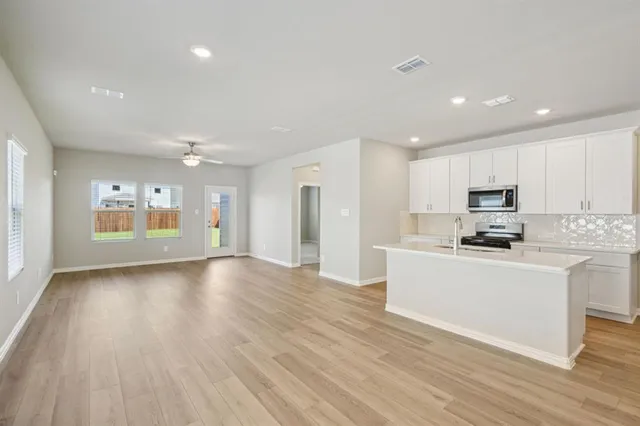 a large kitchen with stainless steel appliances granite countertop a large counter top and a stove top oven