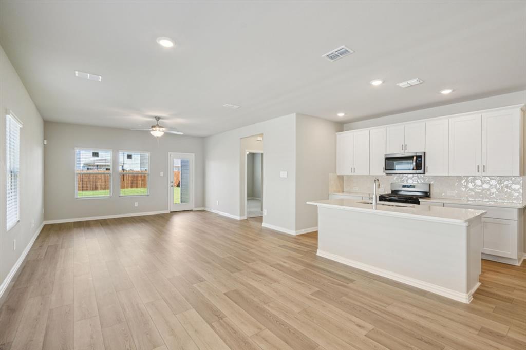 1712 Arches Road Anna, TX 75409 - Photo 13 of 37 a large kitchen with stainless steel appliances granite countertop a large counter top and a stove top oven