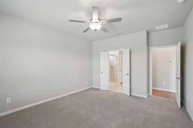 a view of an empty room with a ceiling fan
