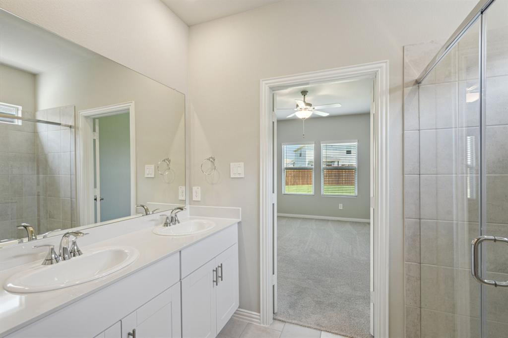 1712 Arches Road Anna, TX 75409 - Photo 22 of 37 a bathroom with a shower sink and mirror