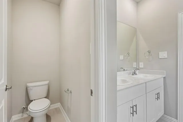 a bathroom with a toilet sink vanity and mirror