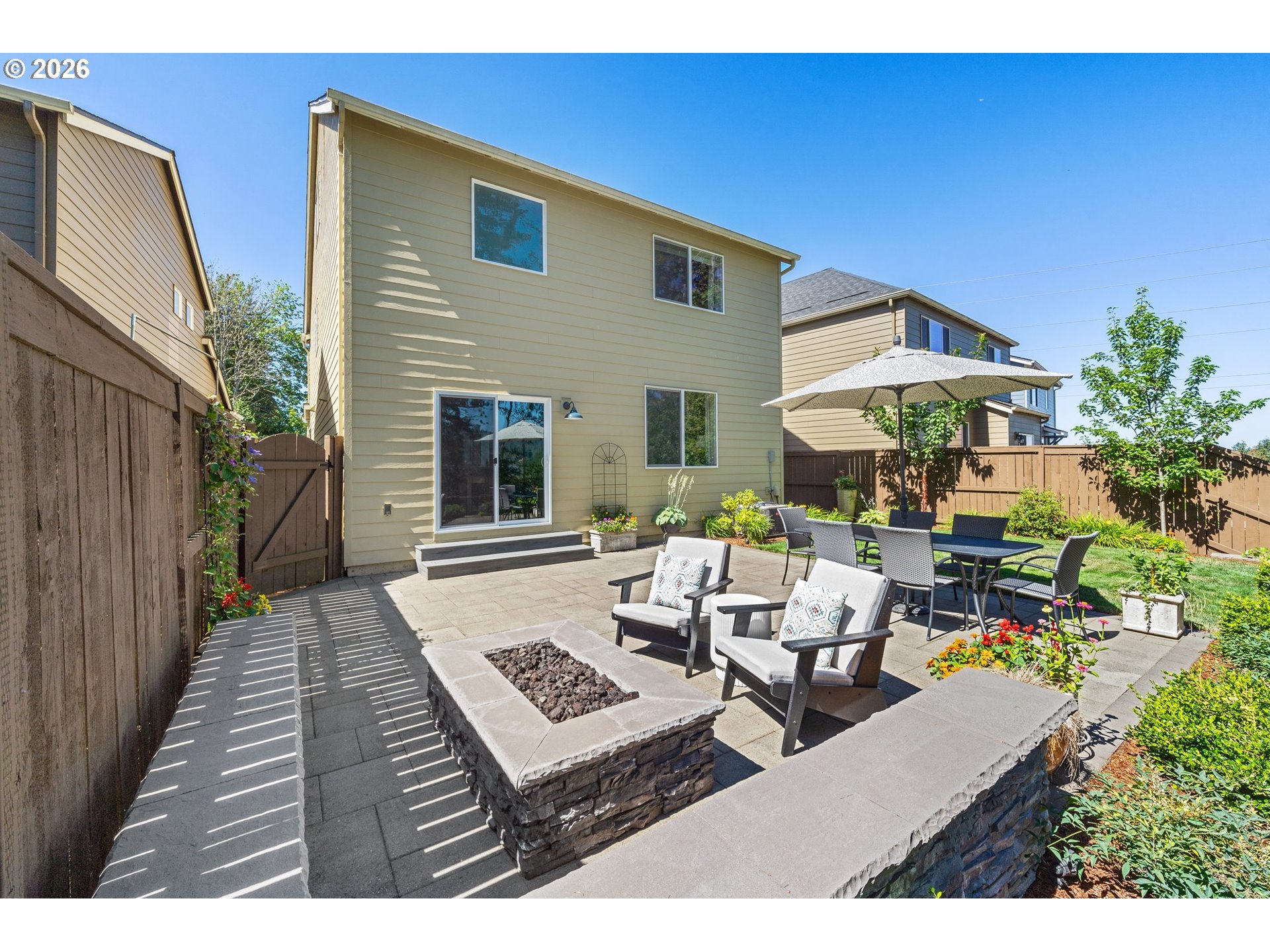 16185 Northwest Liberty Street Portland, OR 97229 - Photo 29 of 33 a view of a patio with couches and table and chairs under an umbrella with wooden fence