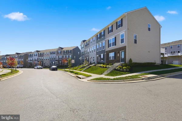 a kitchen with stainless steel appliances granite countertop a refrigerator a stove top oven a sink dishwasher and a refrigerator with wooden floor