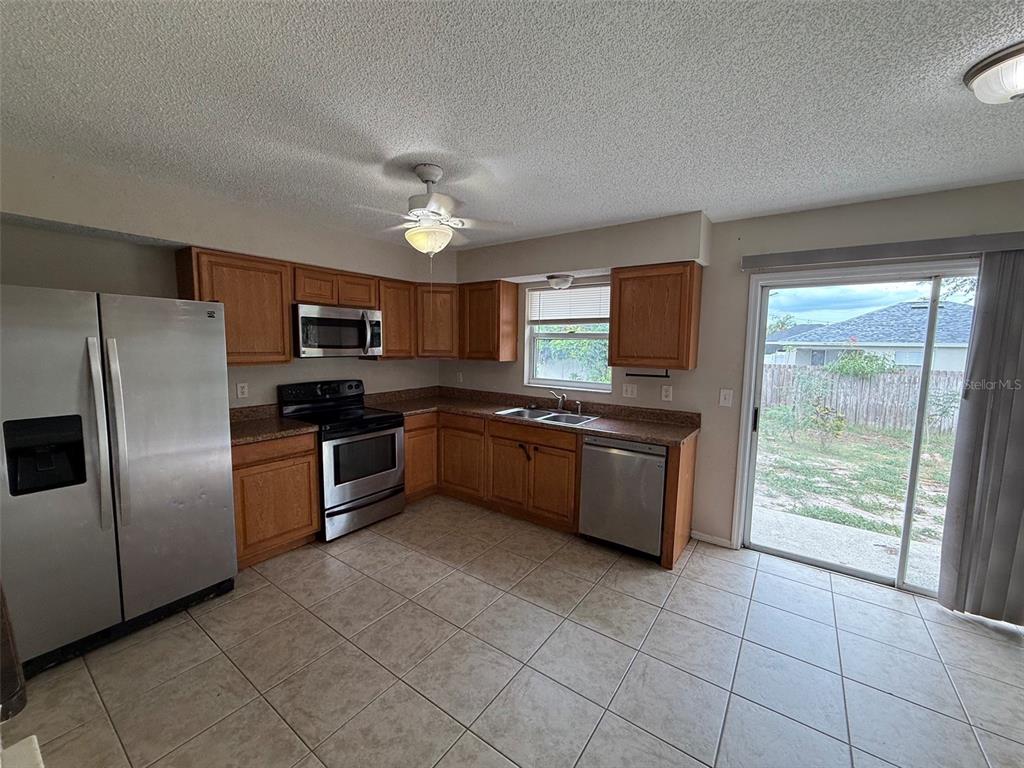 855 Jamaica Road Venice, FL 34293 - Photo 6 of 19 a kitchen with stainless steel appliances granite countertop a stove a sink dishwasher a refrigerator and a microwave oven