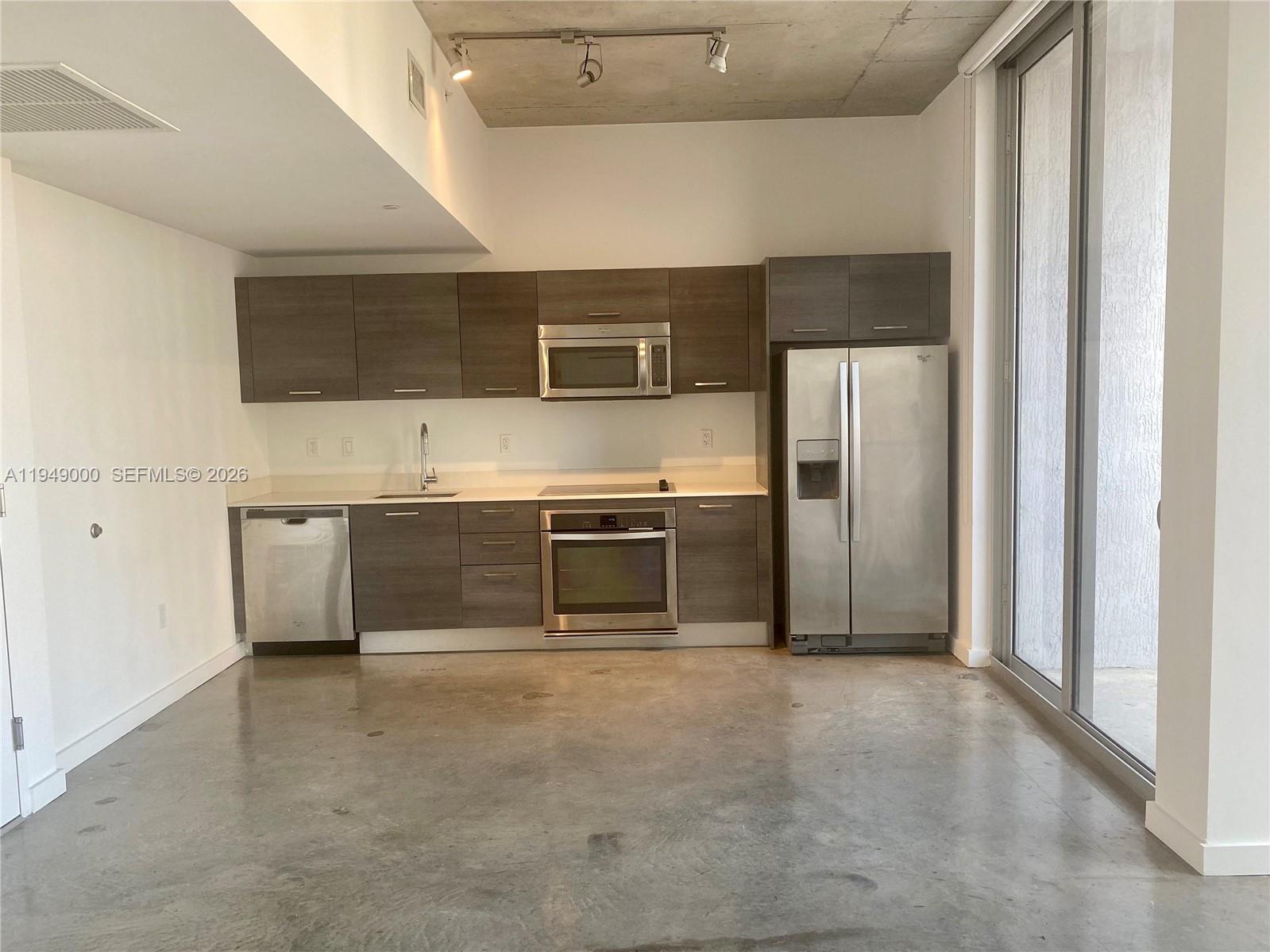 151 Southeast 1st Street, Unit 1108 Miami, FL 33131 - Photo 8 of 10 a kitchen with stainless steel appliances a refrigerator and a stove