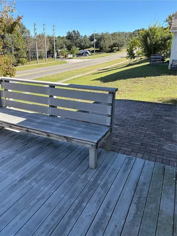 an empty room with wooden floor cabinet and windows