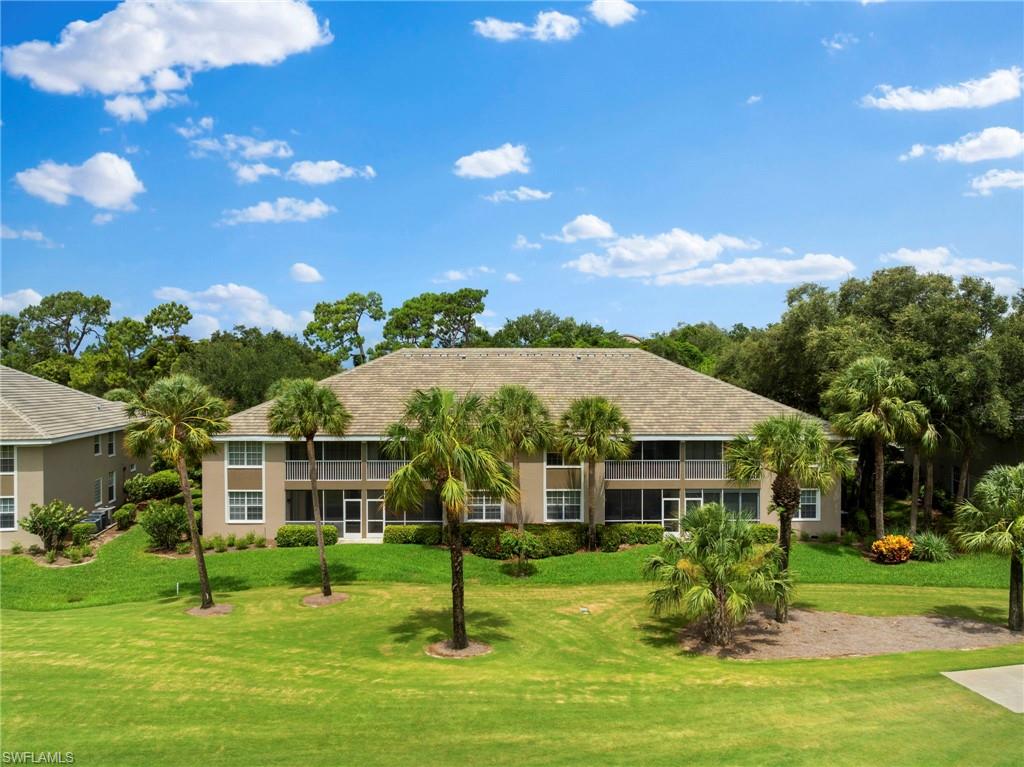 1970 Willow Bend Circle, Unit 203 Naples, FL 34109 - Photo 36 of 42 a front view of a house with a garden