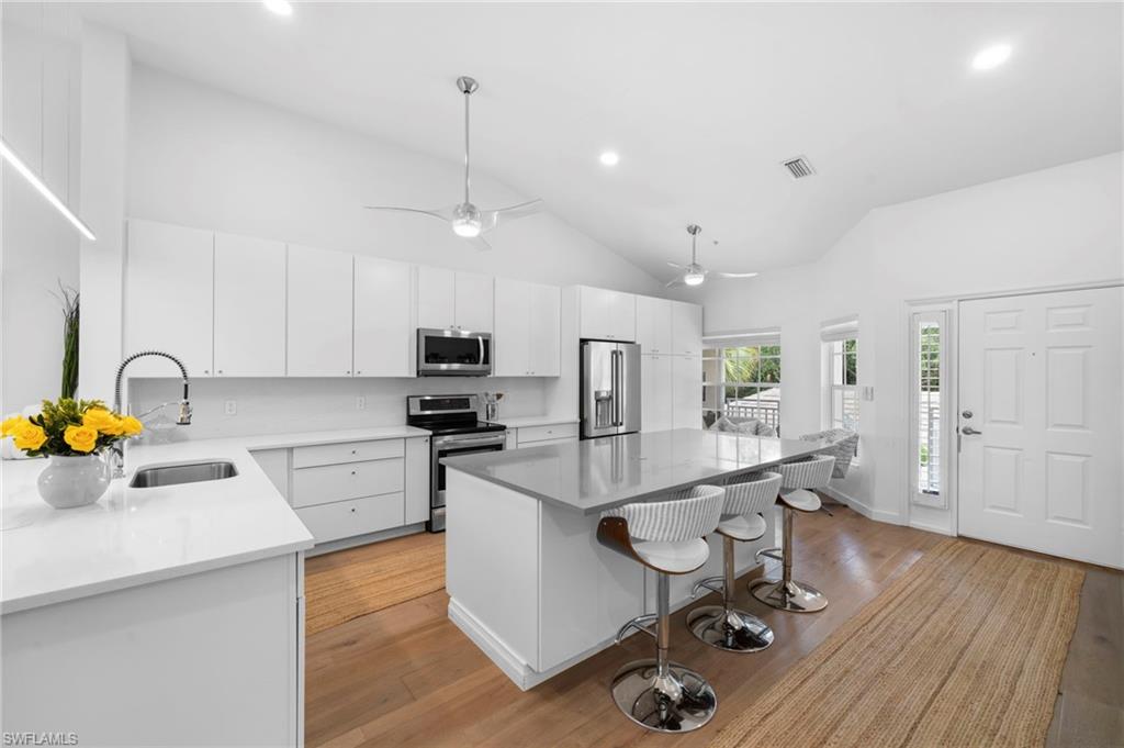 1970 Willow Bend Circle, Unit 203 Naples, FL 34109 - Photo 8 of 42 a kitchen with stainless steel appliances granite countertop a sink dishwasher a stove refrigerator and cabinets with wooden floor