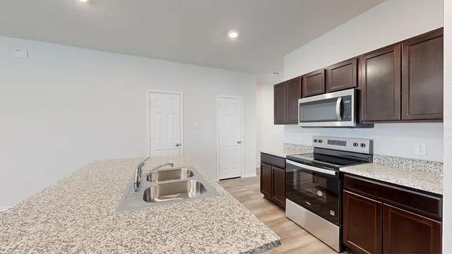 a kitchen with granite countertop a stove and a sink