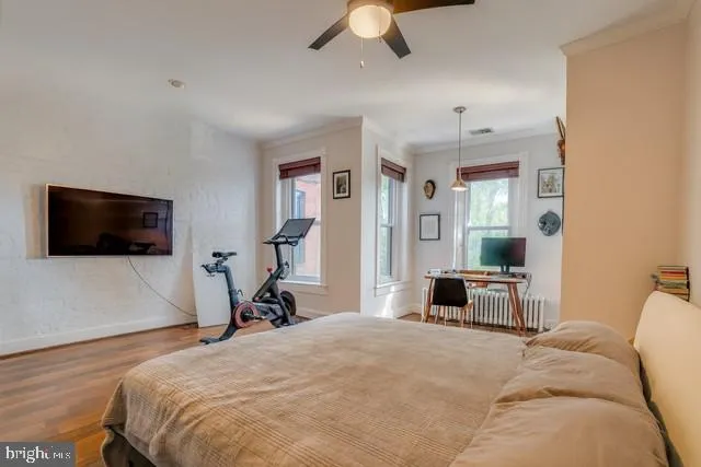 a bedroom with a bed and a flat tv screen on dresser