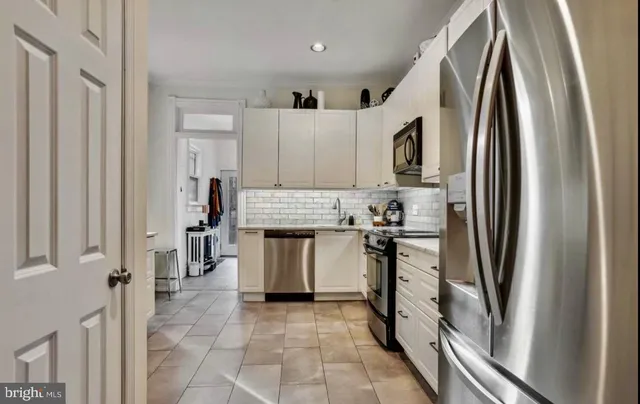 a kitchen with stainless steel appliances granite countertop a refrigerator and a stove