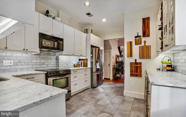 a kitchen with stainless steel appliances granite countertop a refrigerator stove microwave and sink