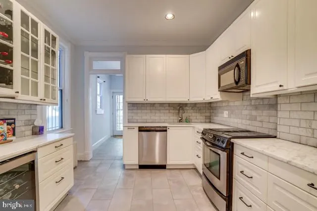 a kitchen with granite countertop cabinets stainless steel appliances and a sink